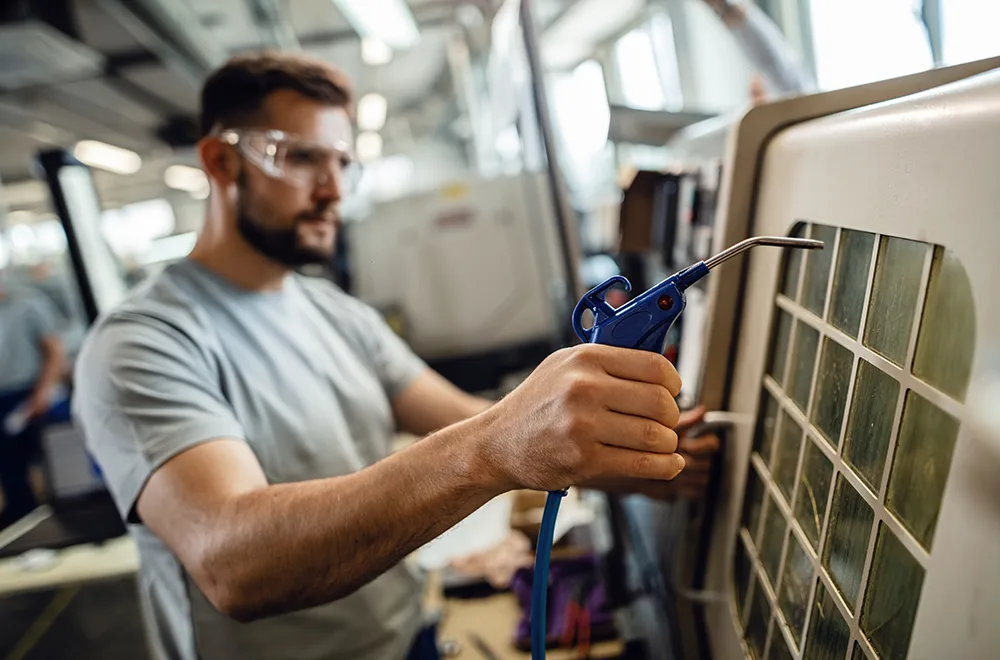 a worker cleaning the filter of a HVAC unit