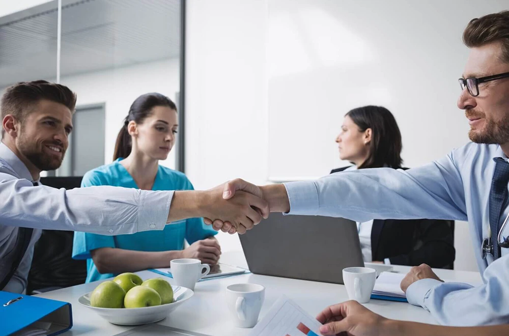 two men shaking hands in a meeting