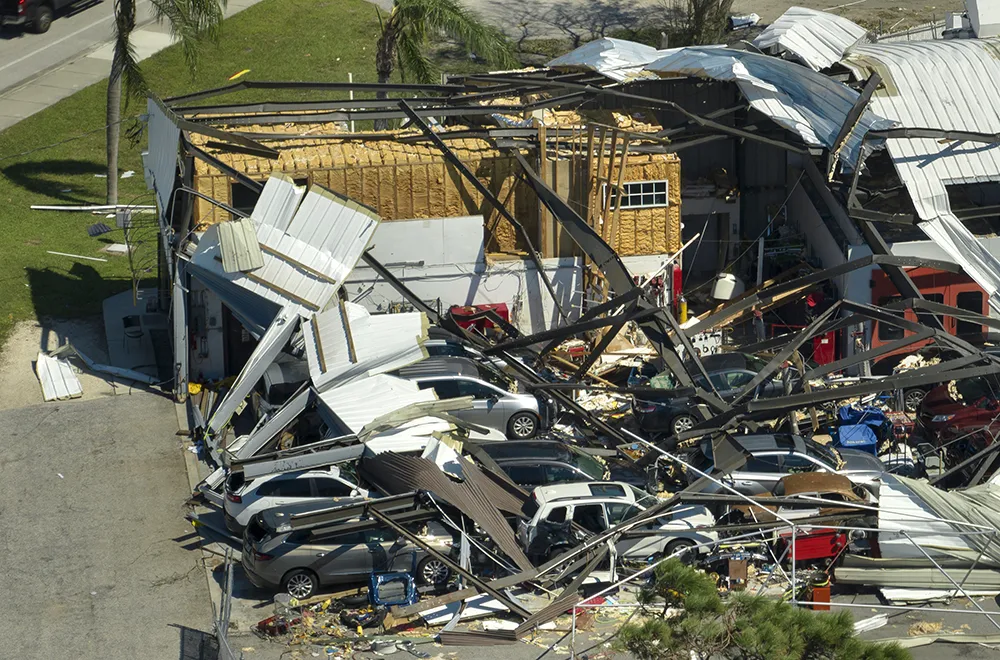 a damaged car lot after a tornado with debris all over