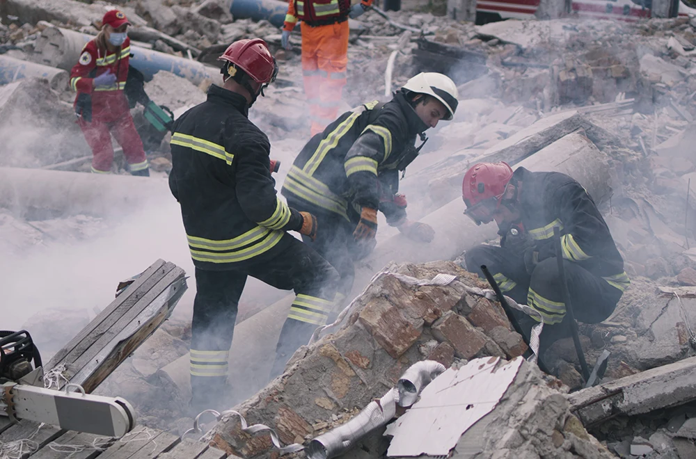 workers searching for survivors in building rubble after a tornado