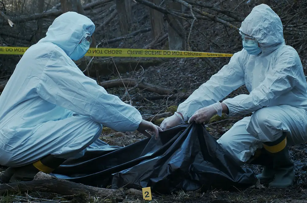 two workers bagging a body