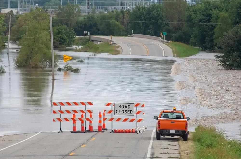 flooding a car stopped infront of a road blocked due to the flood
