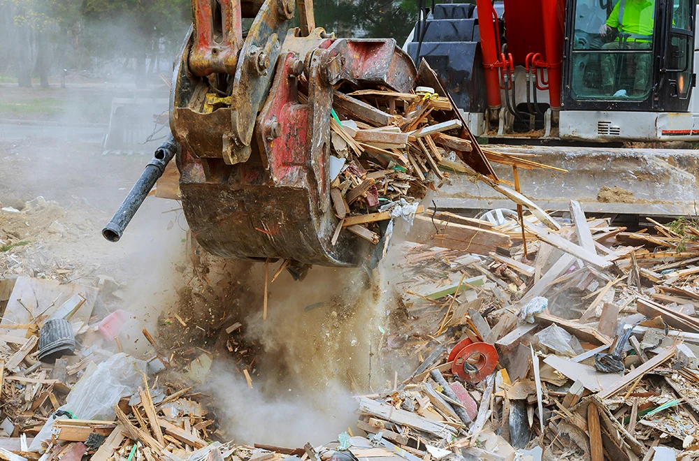 an excavator picking up debris after a storm