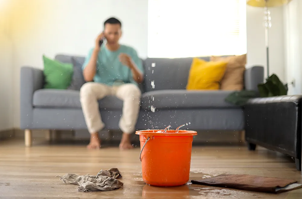 a bucket with water dripping in it from the roof