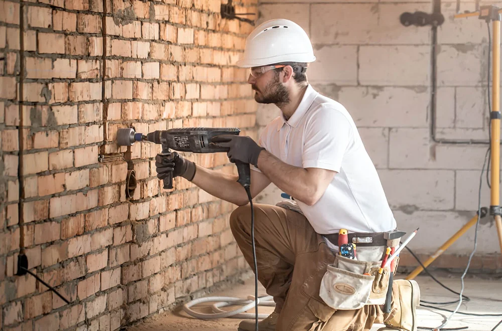 comprehensive-restoration man drilling a wall