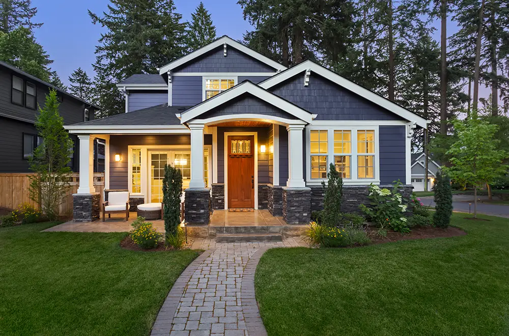 homeowners a blue house with lights on
