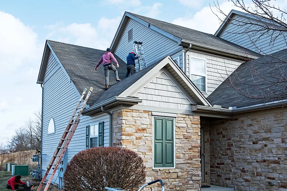 workers on the roof restoring a house